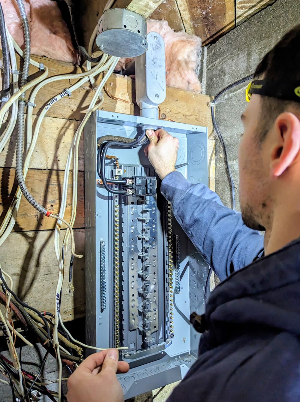 Electrician connecting a new breaker panel